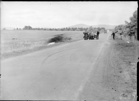 Spectators inspecting motor car at scene of fatal car accident on Northbourne Avenue, looking south.