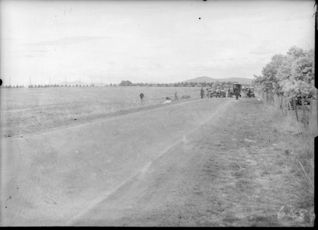 Spectators inspecting damaged motor cars  at scene of fatal car accident on Northbourne Avenue, looking south.
