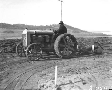 Fordson wheeled tractor hauling a scoop