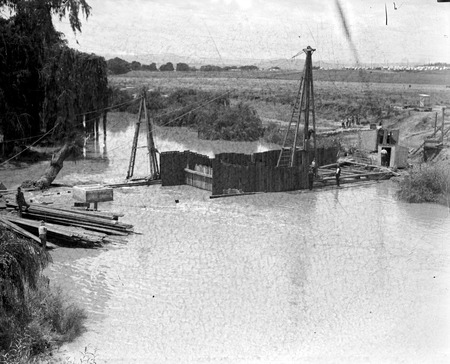 Sewerage tunnel workings near Commonwealth Avenue Bridge with the Molonglo River in flood