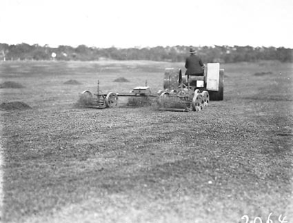 Tractor towing multiple lawn mowers on Royal Canberra golf course