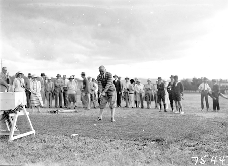 Opening of the extended Canberra Golf Course by Rt. Hon S. M. Bruce. Golfer preparing to tee off before spectators.