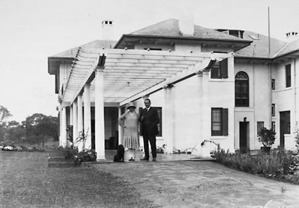 Prime Minister, Right Honourable SM Bruce and Mrs Bruce, with pet dog at the Pergola of the Lodge, Adelaide Avenue, Deakin