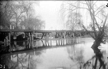 Scotts Crossing Bridge over Molonglo River after flood (was called Church Crossing because of parishioners travelling to St John's Church) - Flood debris on bridge - Trees in river are Weeping Willows