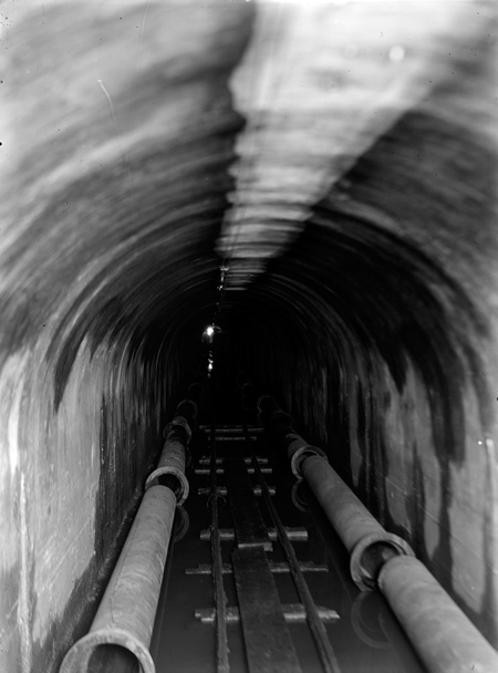 Sewerage tunnel with water pipes being installed.