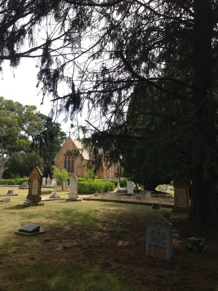 The broken headstone in the foreground of the original photograph has been restored. The original outline can be seen against a new backing in my photograph, and it's been plastered but you can see where the cracks were.