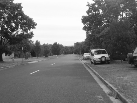 This photo is taken from Chapman Street, not far from Limestone Avenue.  The original caption (Batman Street) must be wrong because Batman Street does not line up with the Sydney Building.  I particularly like this photo because it shows the the Sydney and Melbourne buildings clearly even though they are are a kilometre away.  The house on the far left is immediately before the intersection with Gooreen Street.  The house still exists and is surrounded by the famous 'monster hedge', which I'm glad was preserved.    The next house, on the other side of Gooreen Street, has been demolished and replaced by a set of flats ironically called Heritage Corner.  The house on the far right still exists and now has the gable painted white and the verandah enclosed.  At the end on the other side of Elimatta Street are the two symmetrically placed FCAC C6 houses either side of the walkway into Civic.  The two fire hydrants on the left also still exist.  